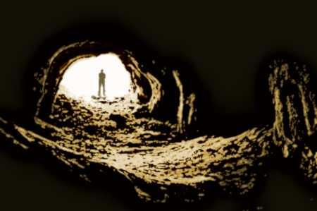 Backlit cavern entrace framing a humanoid figure